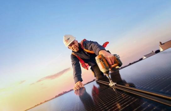 Photograph of man installing solar panel